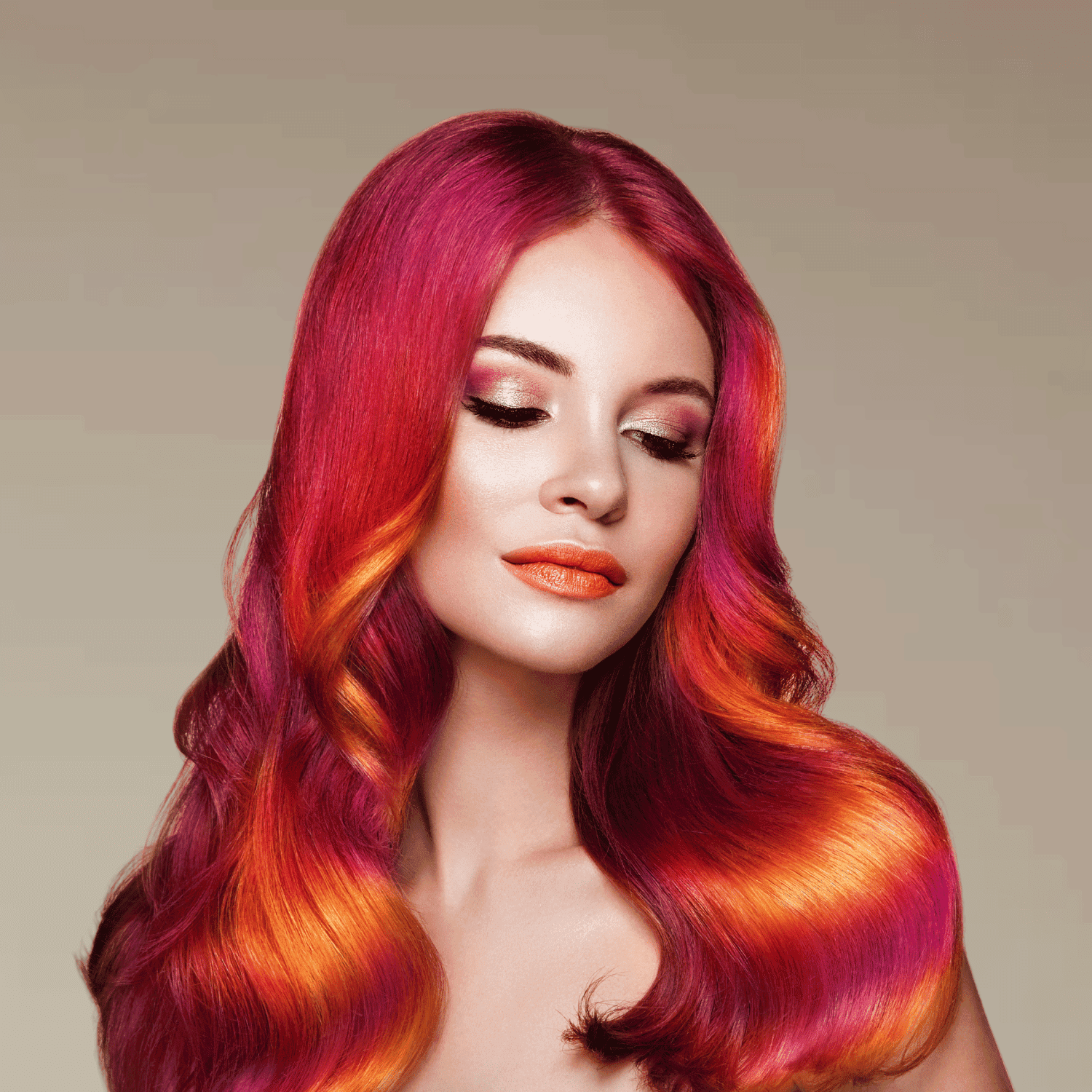 Woman with vibrant pink and orange hair, eyes closed, wearing bold orange lipstick.